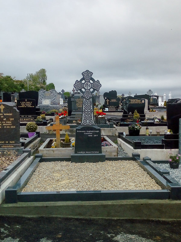 Dark grey polished granite Celtic cross headstone with Celtic engravings throughout, with matching kerbing.